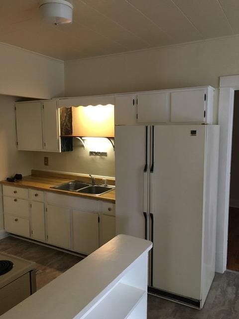 kitchen with dark wood-style floors, light countertops, white cabinets, a sink, and white appliances