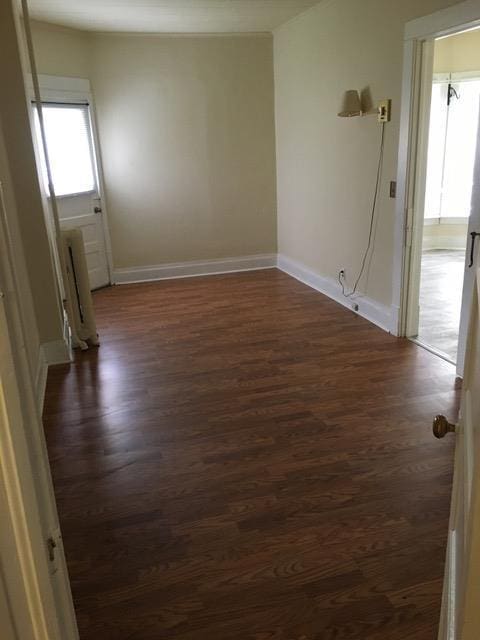 spare room with dark wood finished floors and baseboards