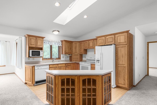 kitchen featuring white appliances, lofted ceiling with skylight, a center island, sink, and light wood-type flooring