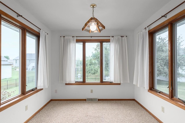 carpeted empty room featuring plenty of natural light