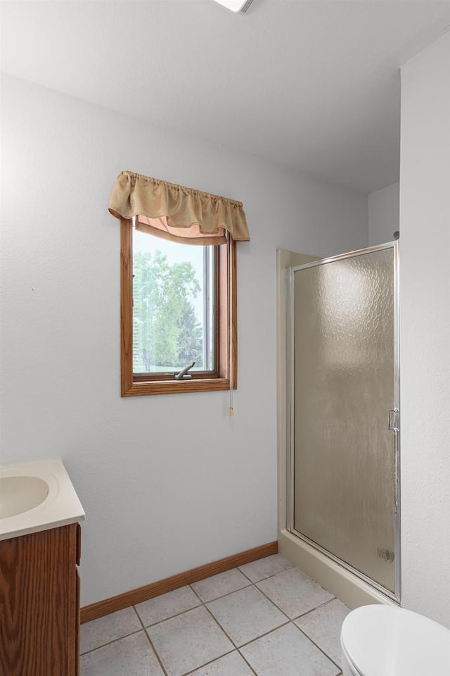 bathroom featuring tile patterned floors, a shower with shower door, toilet, and vanity