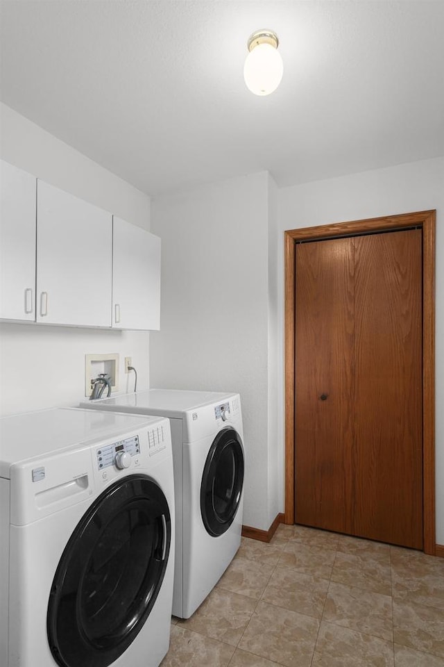 washroom with cabinets and washing machine and dryer