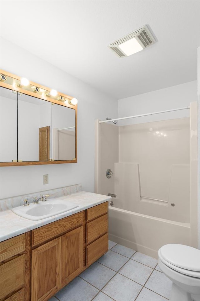 full bathroom featuring washtub / shower combination, tile patterned flooring, toilet, and vanity