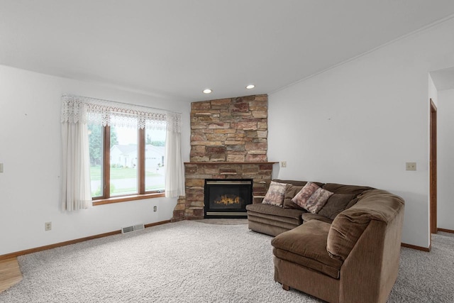 living room featuring carpet and a stone fireplace