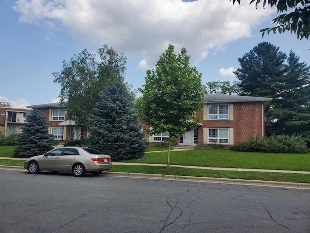 view of front of home with brick siding and a front lawn