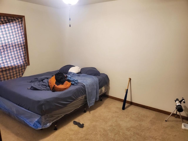 bedroom featuring light carpet and baseboards