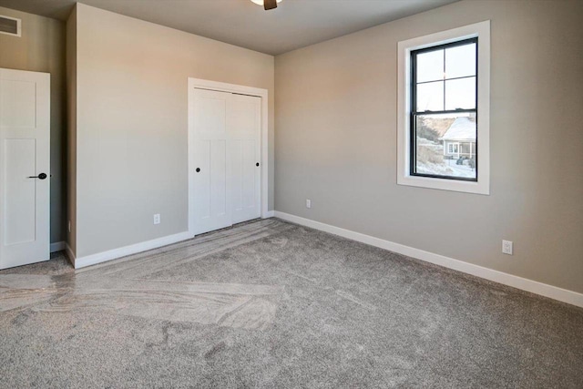 unfurnished bedroom with a closet, carpet flooring, and baseboards