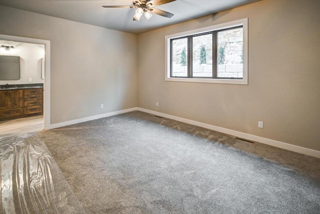 carpeted empty room with baseboards and a ceiling fan