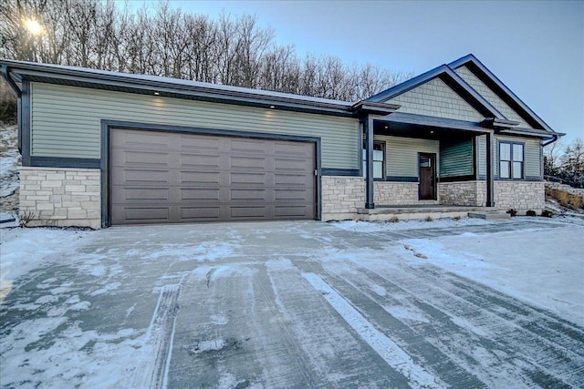 view of front of home featuring a garage, stone siding, and concrete driveway