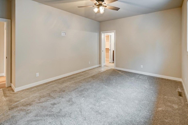 unfurnished room with carpet floors, baseboards, visible vents, and ceiling fan