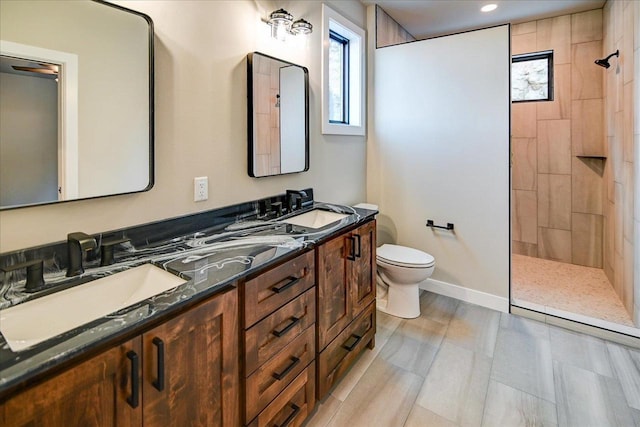 full bath with double vanity, walk in shower, a sink, and toilet