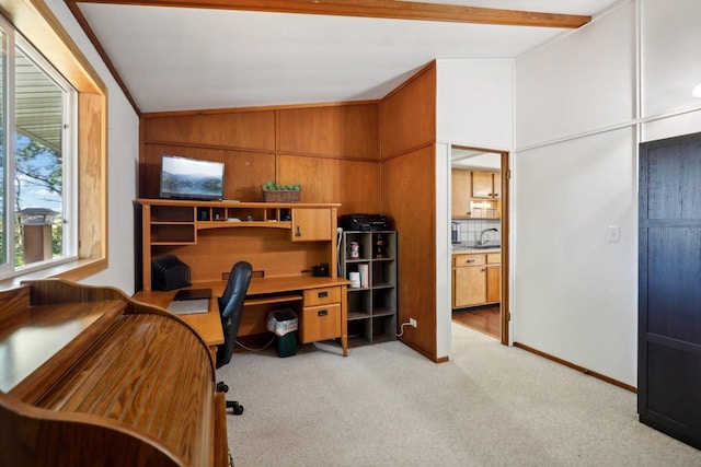 home office with wood walls, crown molding, sink, lofted ceiling, and light colored carpet