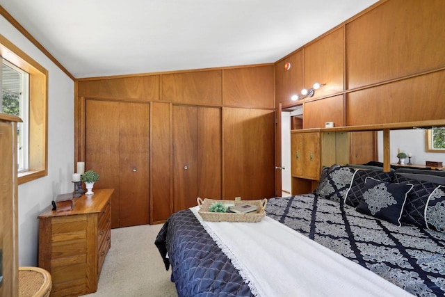 bedroom with crown molding, multiple windows, lofted ceiling, and light carpet