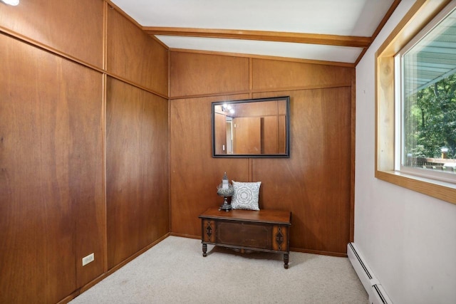 interior space with baseboard heating, wood walls, light carpet, and vaulted ceiling with beams