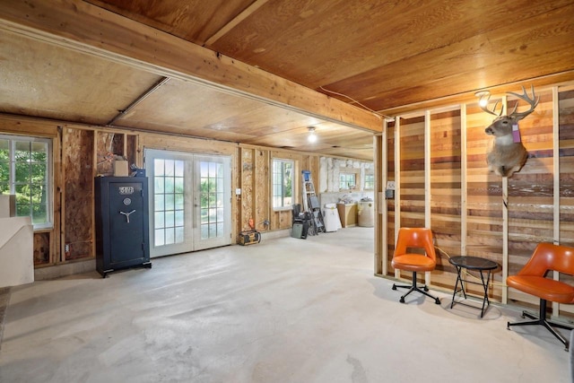 basement with a healthy amount of sunlight, wood ceiling, and french doors