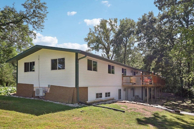 back of house featuring a deck and a lawn