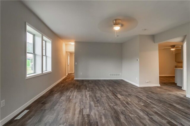 unfurnished room featuring dark wood-type flooring and ceiling fan