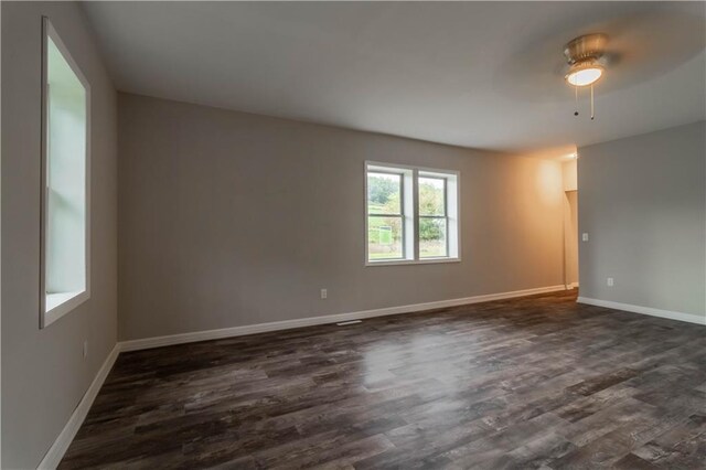 spare room with ceiling fan and dark hardwood / wood-style flooring