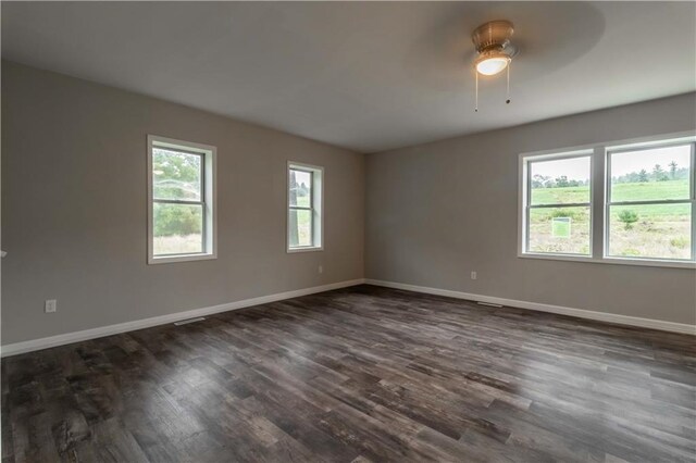 unfurnished room with a healthy amount of sunlight, ceiling fan, and dark hardwood / wood-style floors