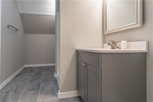 bathroom featuring lofted ceiling and vanity