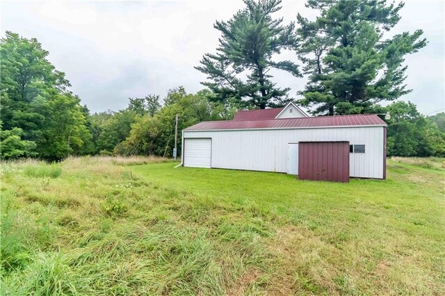 view of yard with a garage and an outbuilding