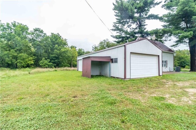 garage featuring cooling unit and a lawn