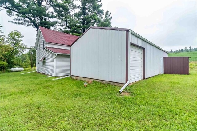 view of outdoor structure featuring a garage and a lawn