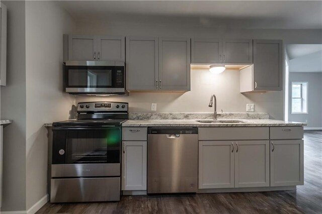 kitchen with dark wood-type flooring, stainless steel appliances, sink, and gray cabinetry