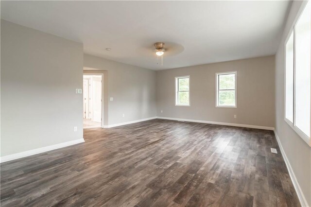 unfurnished room with dark wood-type flooring and ceiling fan