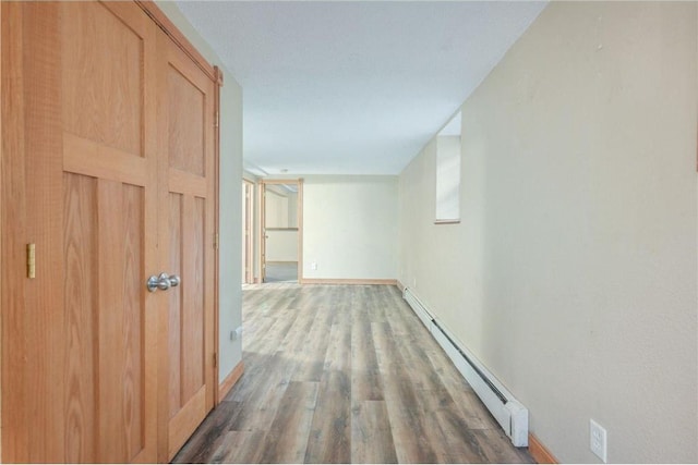 corridor with hardwood / wood-style floors and a baseboard radiator