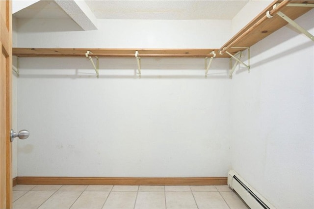 walk in closet featuring a baseboard heating unit and light tile patterned flooring