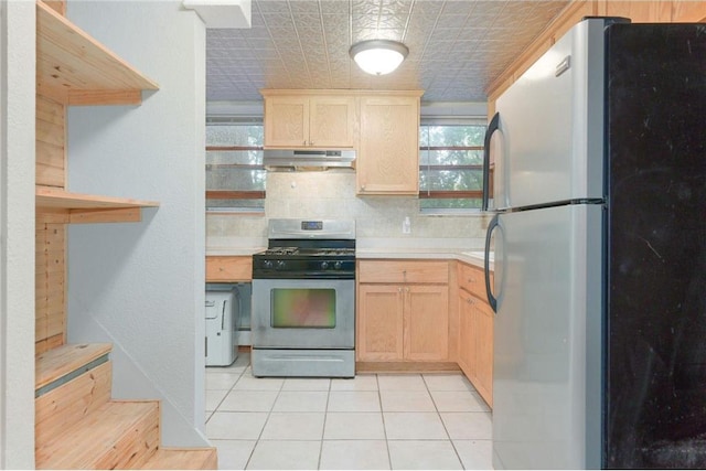 kitchen featuring appliances with stainless steel finishes, light brown cabinetry, backsplash, and light tile patterned floors