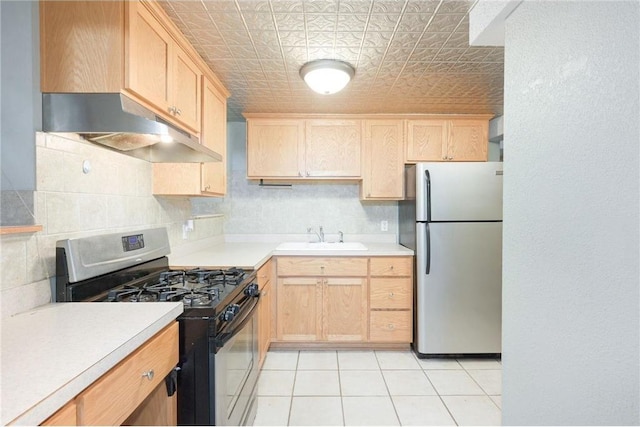 kitchen with appliances with stainless steel finishes, backsplash, light brown cabinetry, and sink