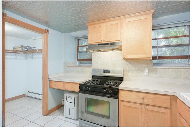 kitchen featuring stainless steel gas stove, light tile patterned floors, a baseboard radiator, decorative backsplash, and light brown cabinets