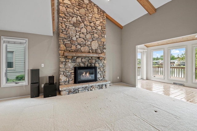 unfurnished living room featuring high vaulted ceiling, a fireplace, carpet, and beam ceiling