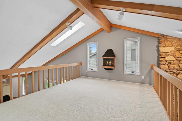 additional living space featuring carpet floors and lofted ceiling with skylight