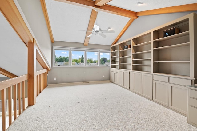 interior space featuring lofted ceiling with beams, ceiling fan, and carpet flooring