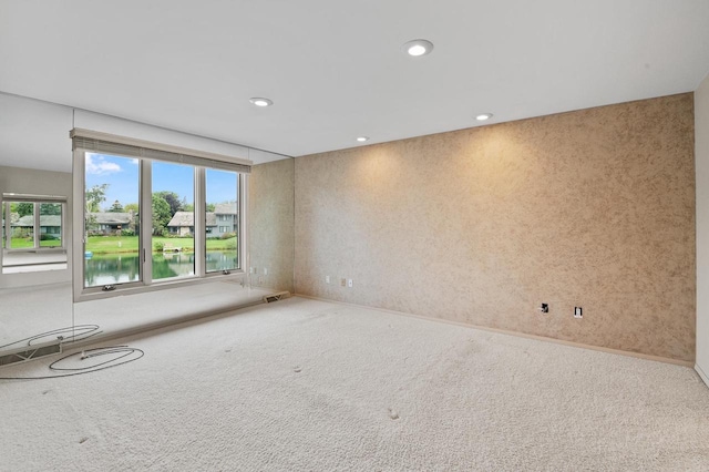 empty room featuring carpet flooring and a water view