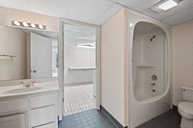 full bathroom with tile patterned floors, toilet, a paneled ceiling, shower / bathing tub combination, and vanity