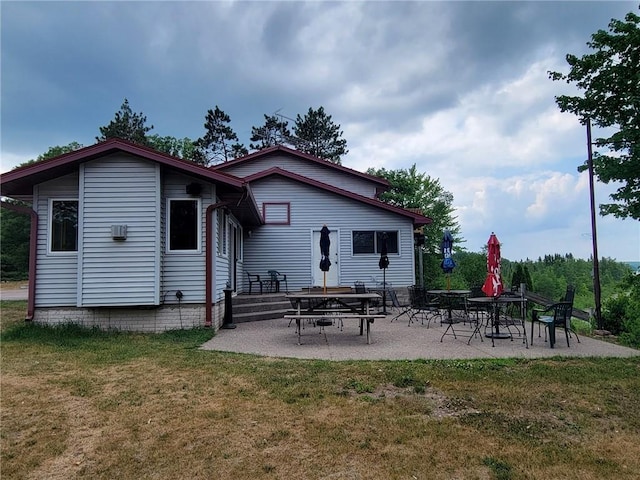 back of property with a lawn and a patio area