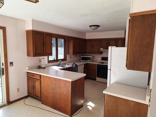 kitchen with white appliances, kitchen peninsula, and sink