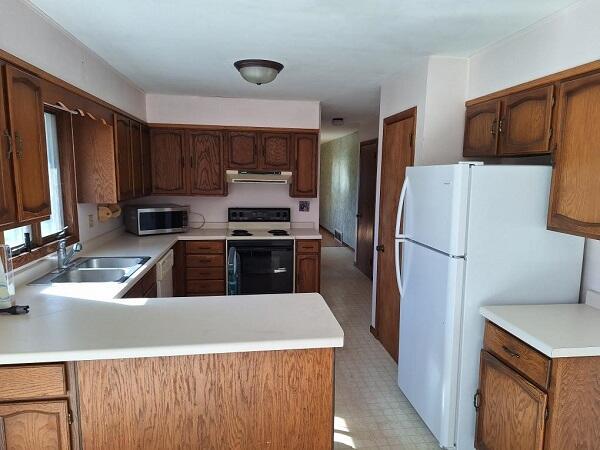 kitchen featuring kitchen peninsula, sink, and white appliances