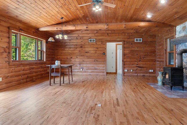 dining room with light hardwood / wood-style floors, a wood stove, wood ceiling, and vaulted ceiling