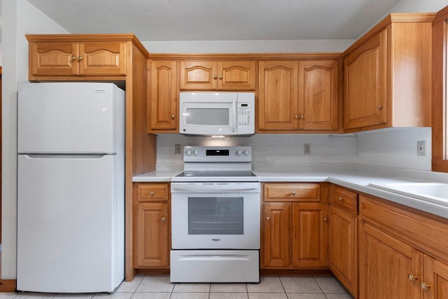 kitchen with white appliances and light tile patterned flooring