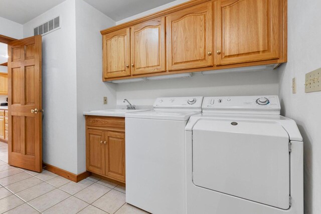 washroom featuring cabinets, washer and dryer, light tile patterned flooring, and sink