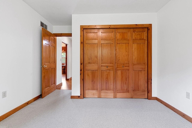 unfurnished bedroom featuring carpet floors, visible vents, and baseboards