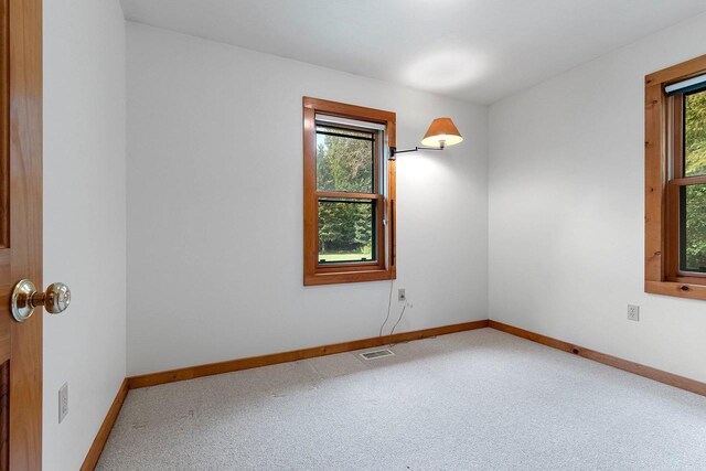 carpeted empty room with visible vents and baseboards