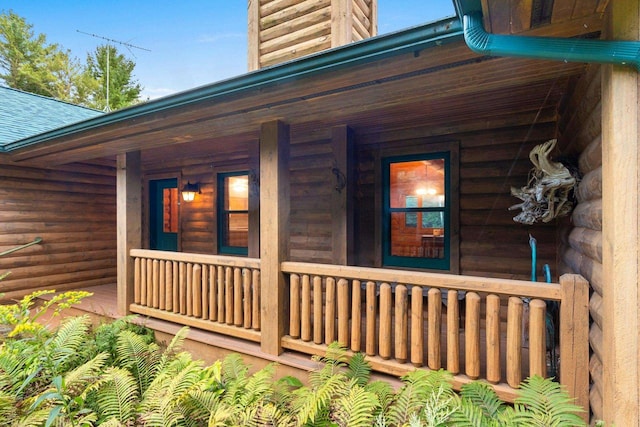 view of side of home featuring covered porch and roof with shingles