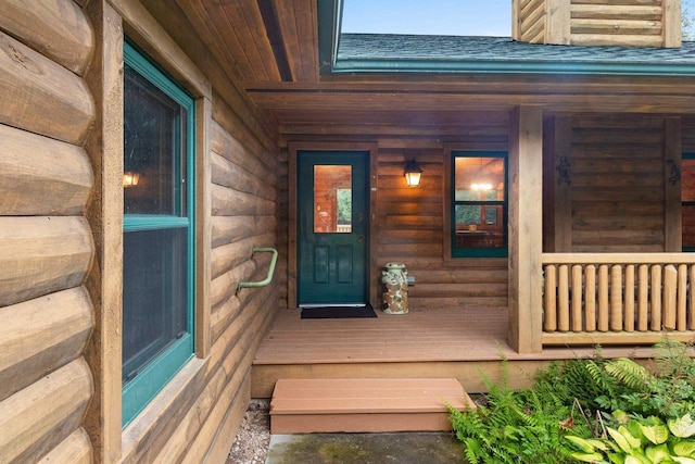 property entrance featuring a shingled roof and a porch