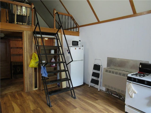 staircase featuring lofted ceiling, hardwood / wood-style floors, and radiator heating unit